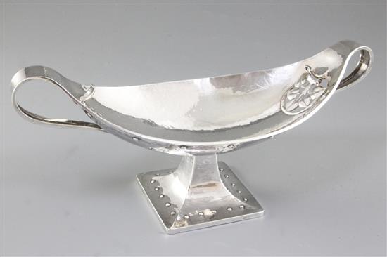 A George V Arts & Crafts silver navette shaped two handled dish, by Albert Edward Jones, Width 12 ¾”/320mm Weight: 18.3oz/520grms